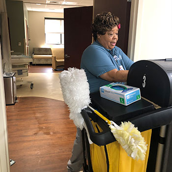  A woman stands by a card with cleaning tools