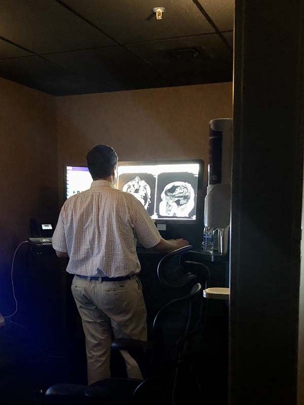 Man standing and looking at brain x-ray