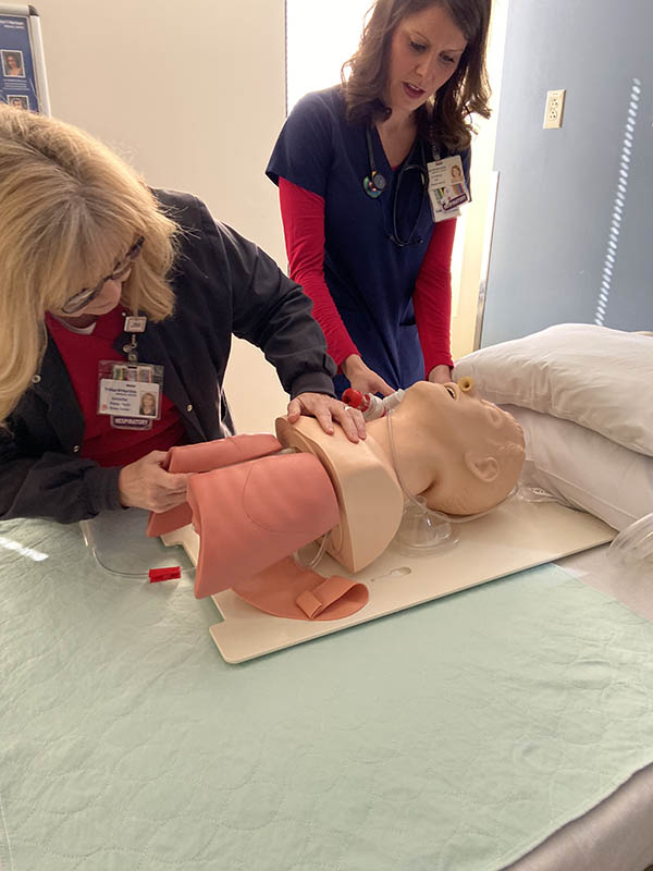 Lindsey and Annette set up an example dummy for a breathing treatment demonstration